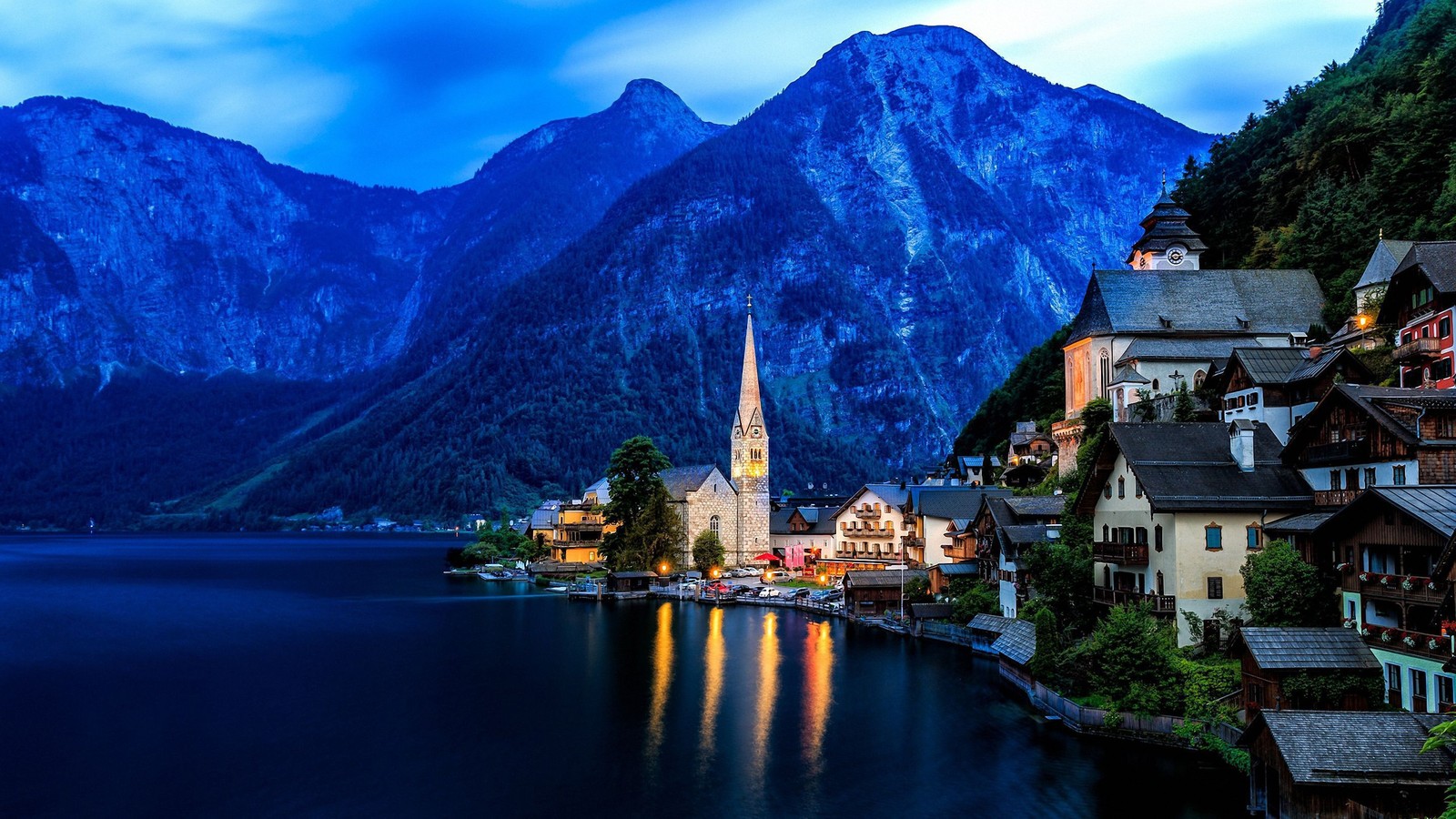 Uma vista de uma cidade na margem de um lago com montanhas ao fundo (hallstatt, natureza, montanha, marco, cadeia de montanhas)