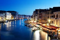 Serenidad nocturna en el Gran Canal: reflejos del Puente de Rialto y góndolas