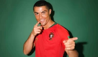 Cristiano Ronaldo in a red Portugal jersey, playfully pointing with a thumbs-up gesture against a green background.