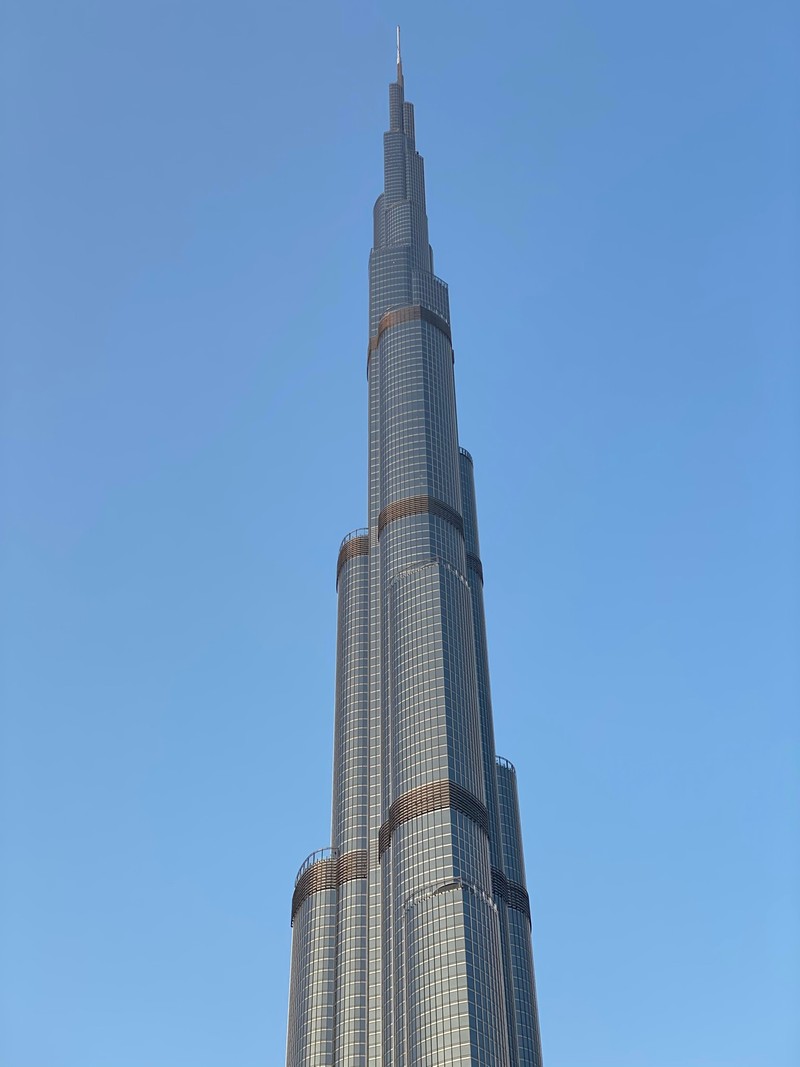 Панорама высокого здания с часами на вершине (дубай, dubai, burj khalifa, небоскреб, национальная историческая достопримечательность)