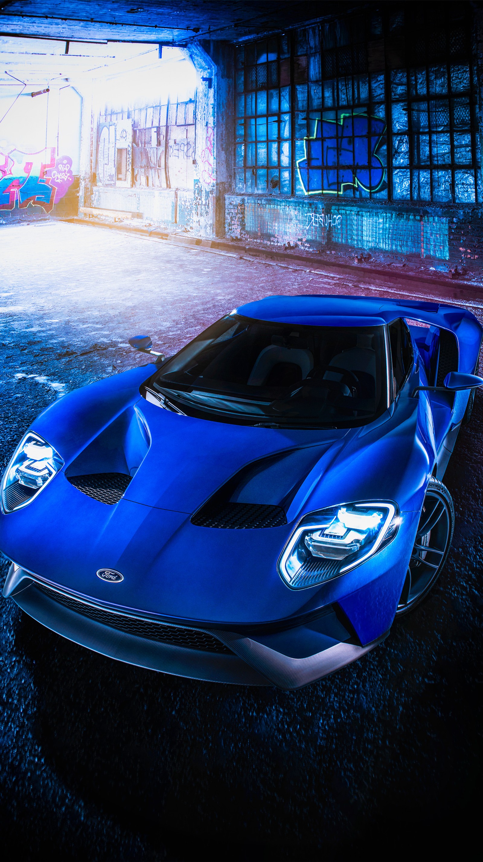 A close up of a blue sports car parked in a parking garage (2017, ford, gt)