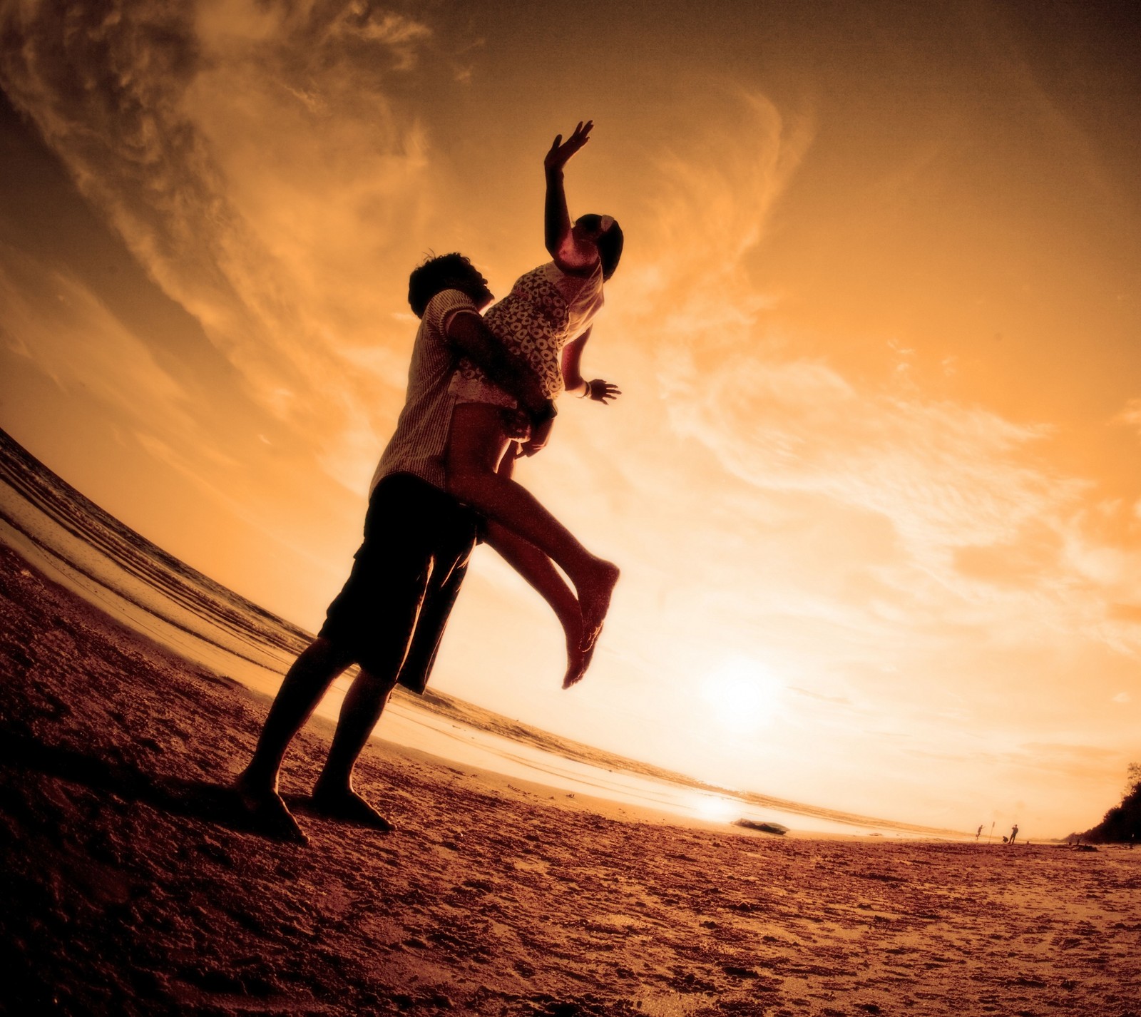 There is a man and woman standing on the beach at sunset (amo, happy, love)