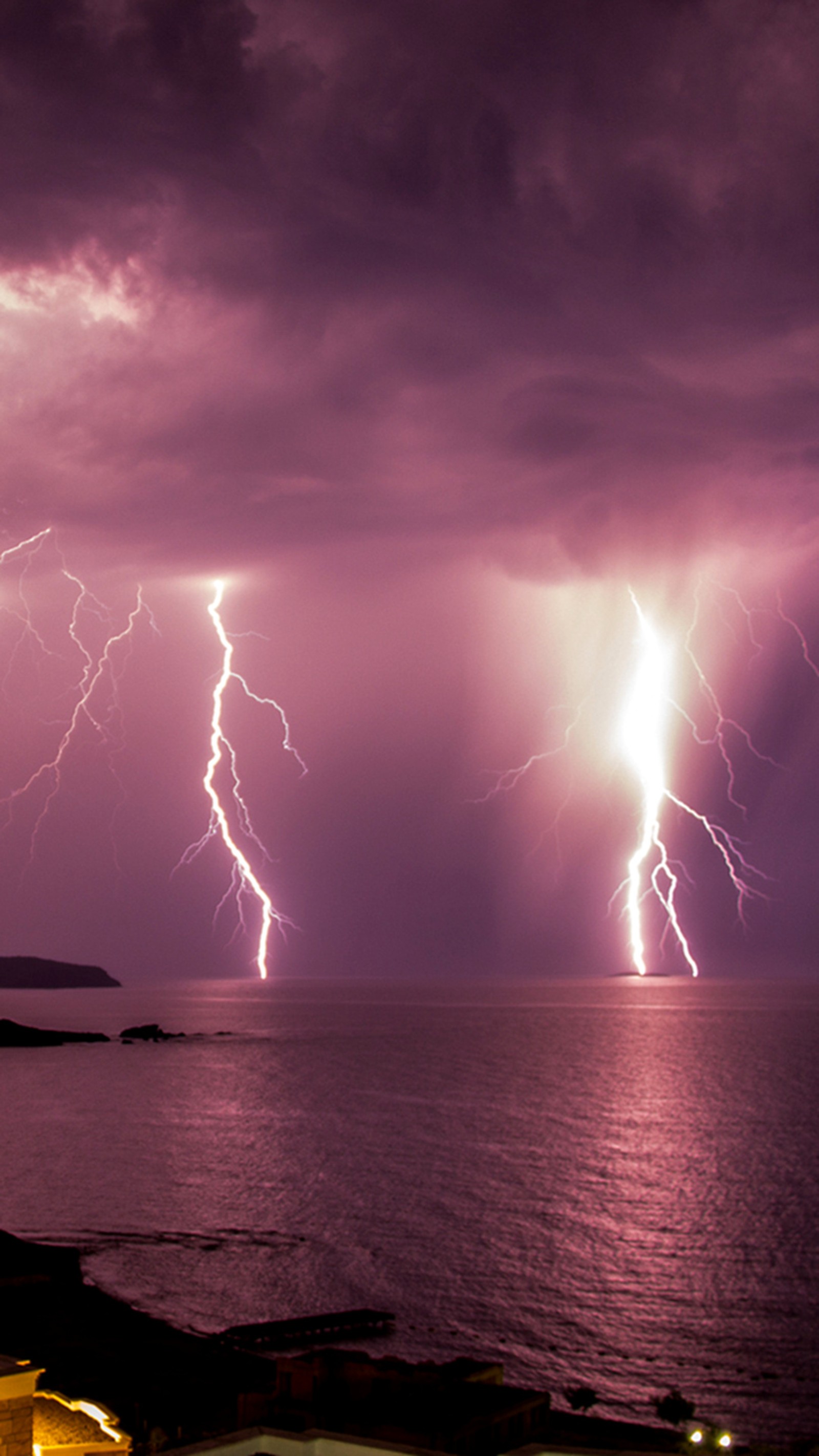 Relâmpagos sobre o oceano e uma praia com um céu roxo (praia, tempestade)