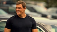 Alan Ritchson as Jack Reacher in a parking lot scene from the TV series "Reacher.