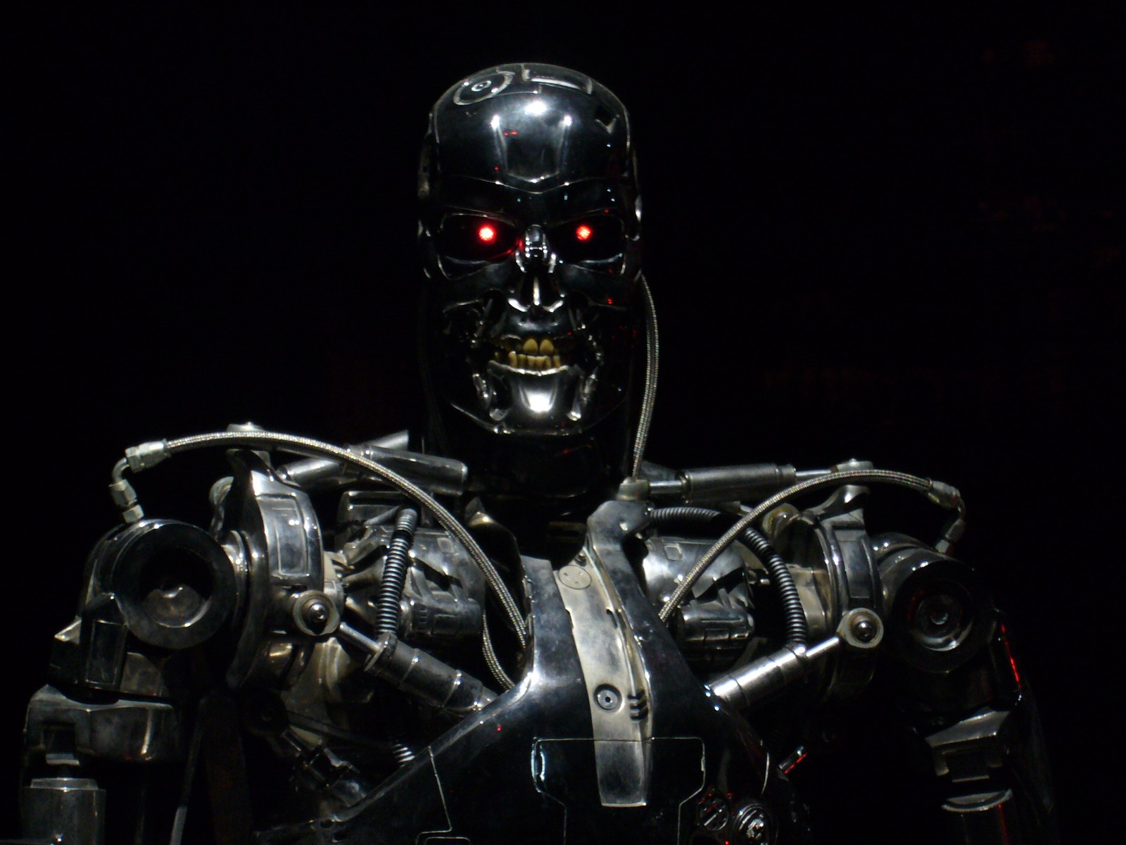 Un primer plano de un robot con ojos rojos sobre un fondo negro (terminador, terminator, robot, figura de acción, tecnología)