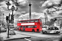 Roter Doppeldeckerbus in urbanem London, umgeben von einer schwarz-weißen Metropole