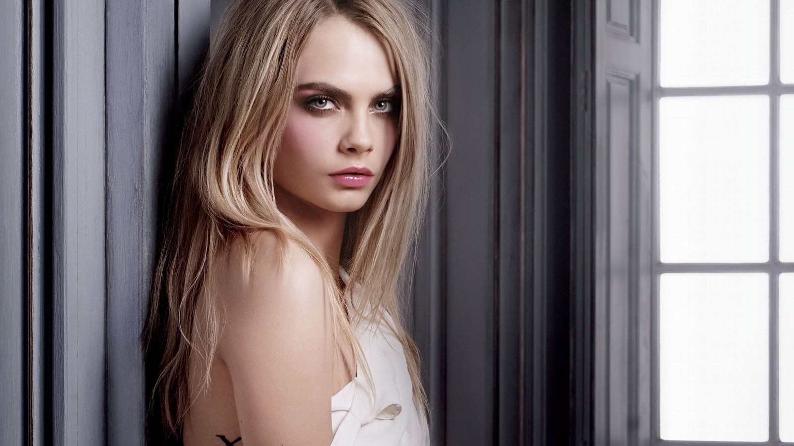 A close up of a woman with long hair leaning against a wall (model, lip, hairstyle, skin, shoulder)