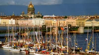 Scène portuaire vibrante mettant en valeur de grands navires et un port animé sur fond d'une silhouette urbaine historique.