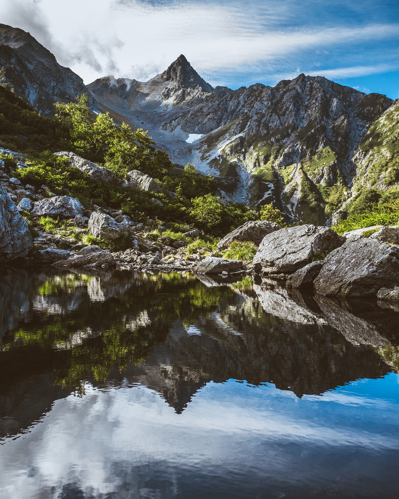 Eine bergkette mit einem see in der mitte (berg, gebirgskette, berglandschaft, alpen, gebirgige landformen)