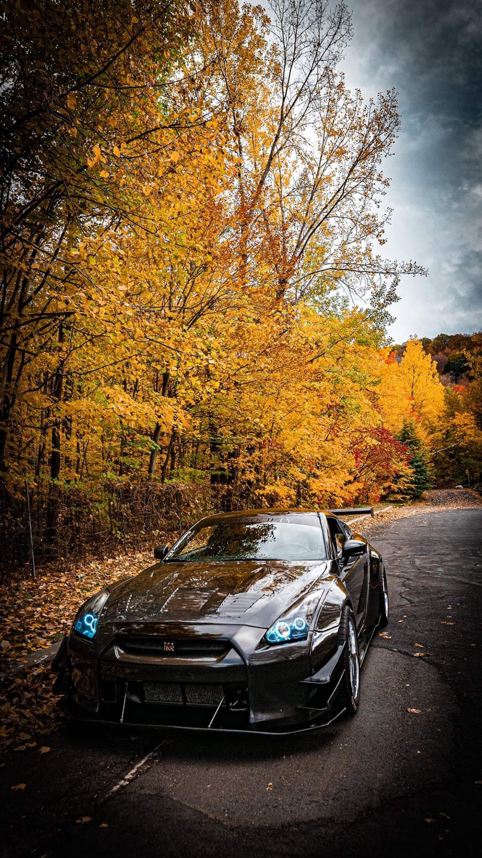 A close up of a black sports car parked on a road (car, cars, cool, gtr nissan, super)