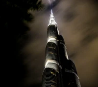 Rascacielos iluminado que perfora el cielo nocturno