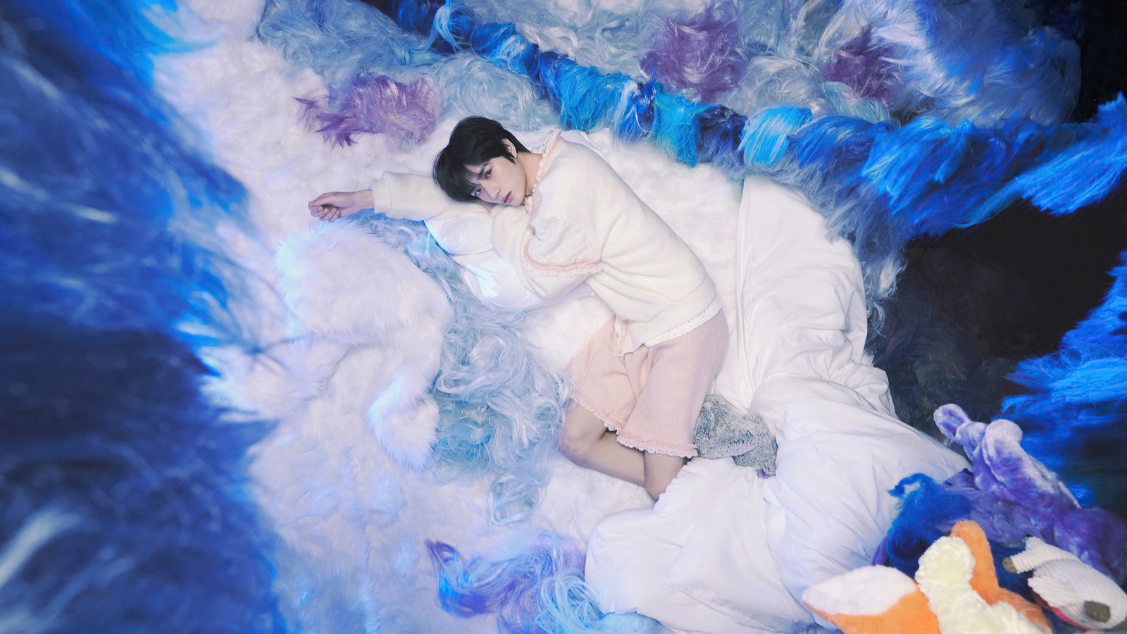 Eine frau in einem weißen kleid liegt auf einem bett mit blauen federn (txt, 투모로우바이투게더, kpop, tomorrow x together, k pop)