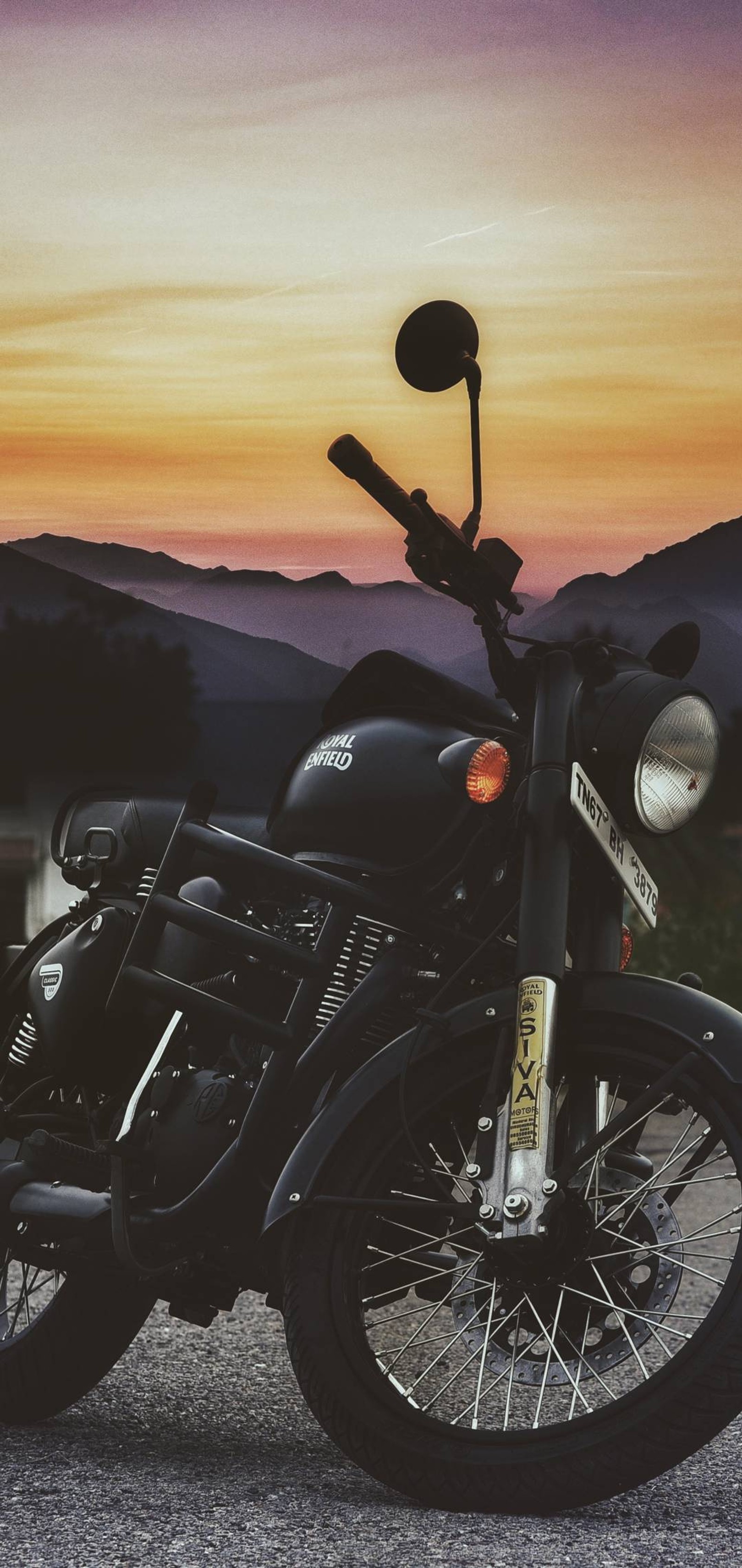 There is a motorcycle parked on the side of the road (royal enfield, bullet)