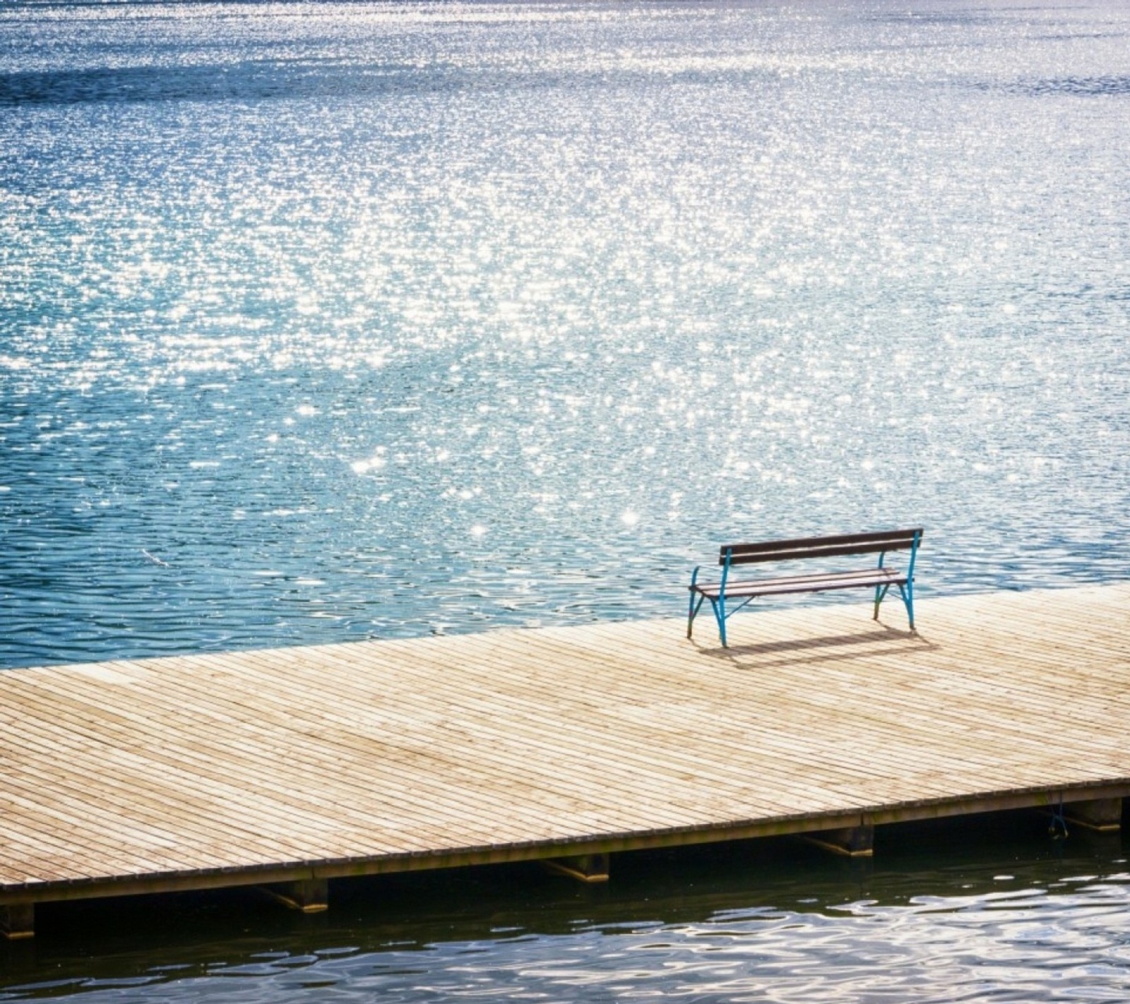 Il y a un banc sur un quai à côté de l'eau (beau, ciel, solitaire, nature, paradis)