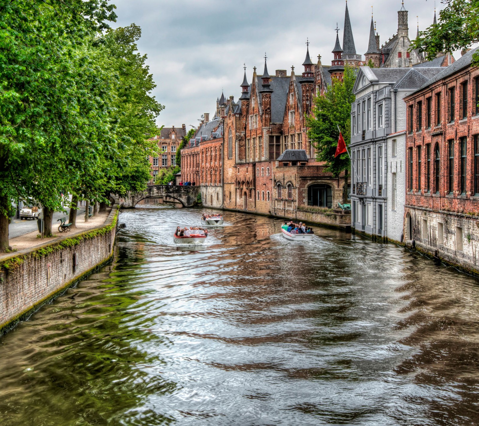 Uma vista aérea de um canal com barcos e uma igreja ao fundo (edifício, campo, hdr, flúmen, árvore)