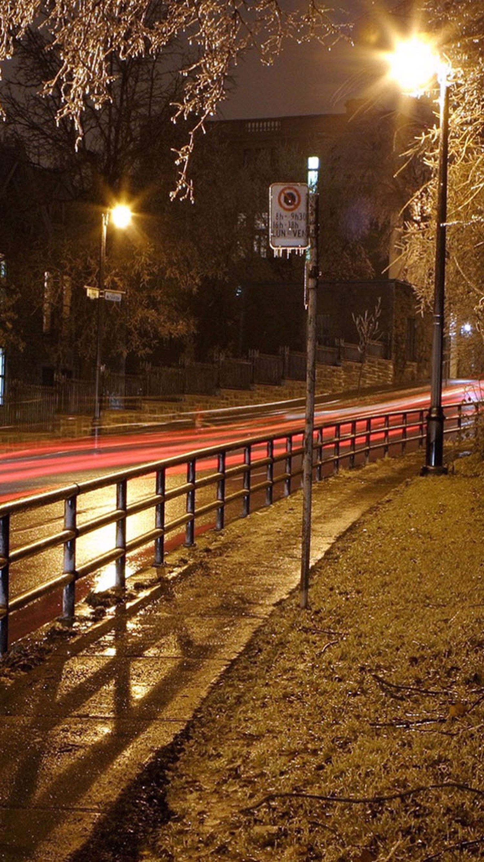 Nighttime view of a street with a fence and a street light (light, night)