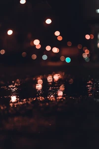 Luces de la ciudad reflejadas en una noche lluviosa