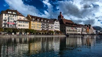 Charming Lakeside Cityscape with Reflections and Dramatic Clouds