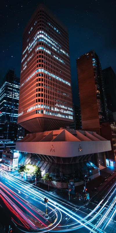 Illuminated Skyscraper in Dynamic Cityscape at Night