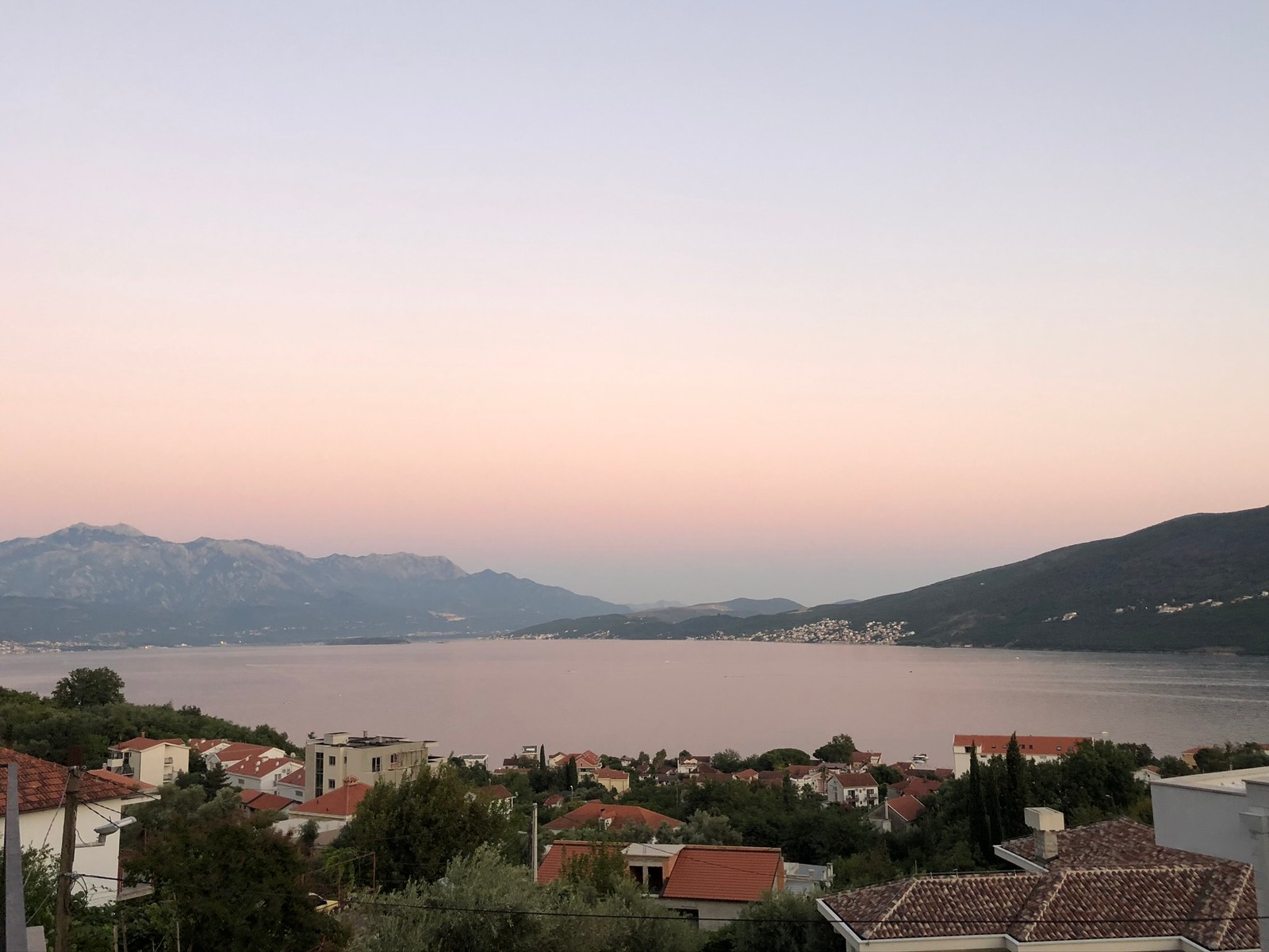 Vue large d'une ville avec un lac et des montagnes en arrière-plan (formes montagneuses, ressources en eau, hauts plateaux, colline, paysage)