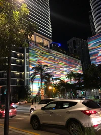 Vida nocturna vibrante en la metrópoli de Miami con arquitectura moderna y coches compactos