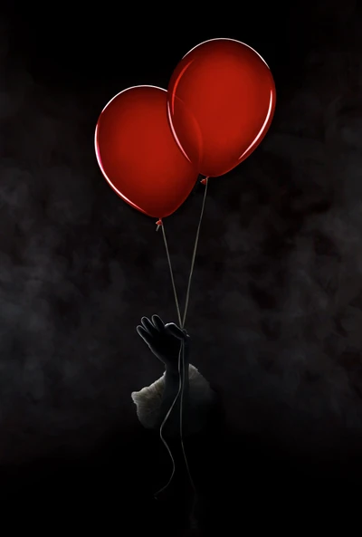 Joyful Gesture: Two Red Balloons Against a Cloudy Backdrop