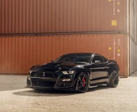 Elegante Ford Mustang Shelby GT500 negro contra fondo industrial