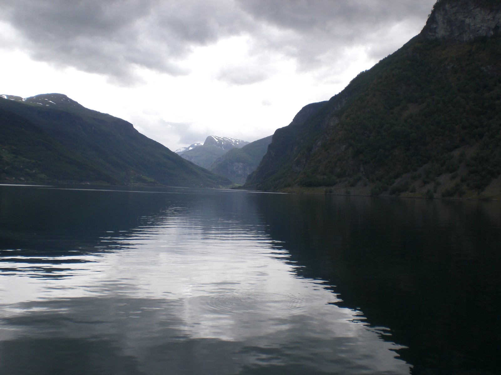 Un bateau flottant dans l'eau près des montagnes (fjord, lake district, lac glaciaire, lac, hauts plateaux)