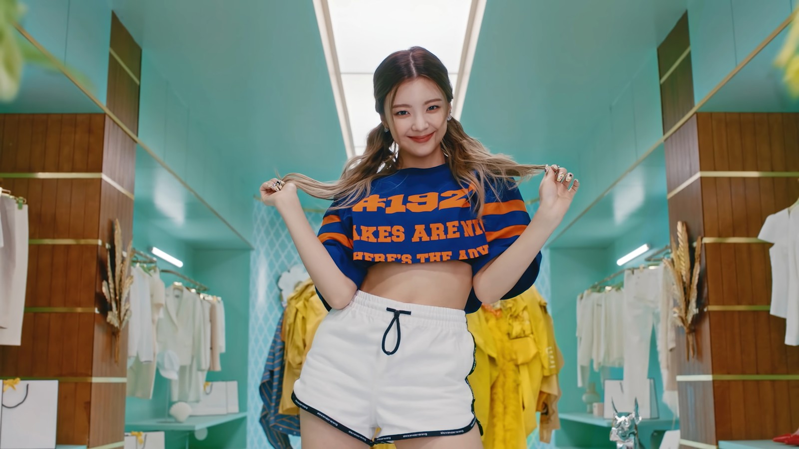 Une femme en chemise bleue et shorts blancs se tenant dans une pièce (itzy, kpop, 있지, k pop, groupe de filles coréen)