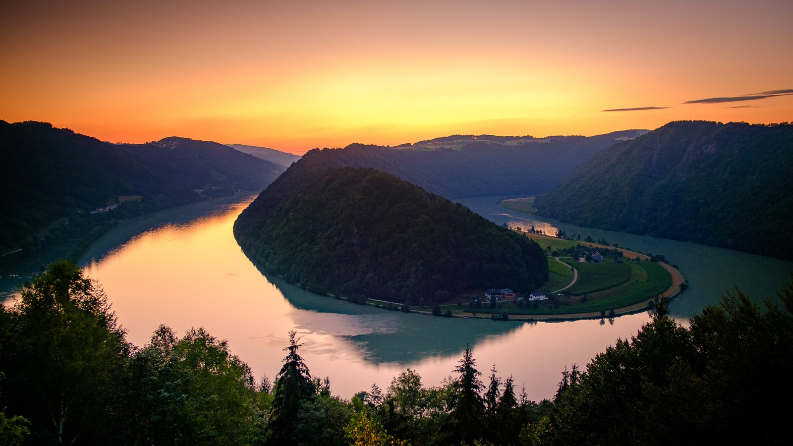 Una vista de un río que corre a través de un valle verde y frondoso (naturaleza, lago, escenario montañoso, danubio, mañana)