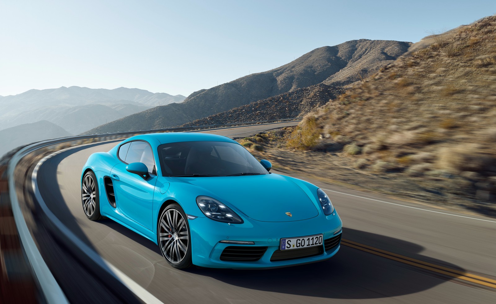 El porsche cayman está conduciendo por una carretera de montaña (porsche, coche, porsche cayman s, supercoche, coche deportivo)