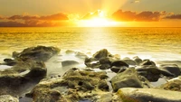 Golden Sunset Over Tranquil Shoreline Rocks