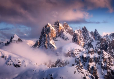 Majestuosos picos montañosos cubiertos de nieve al anochecer