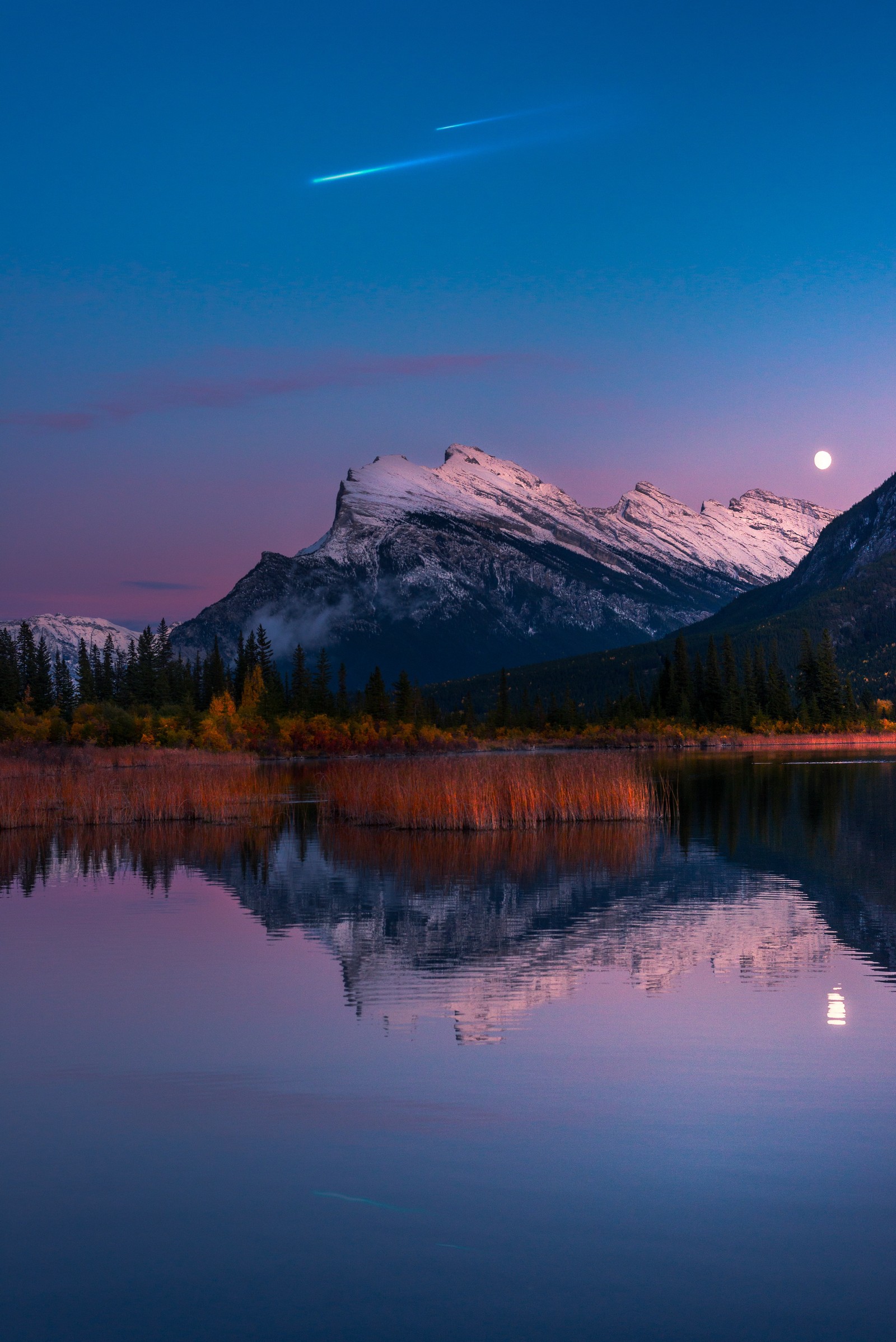 As montanhas se refletem em um lago ao anoitecer com uma lua cheia (vermilion lakes, canadá, rocosas canadenses, montanhas glaciais, coberto de neve)