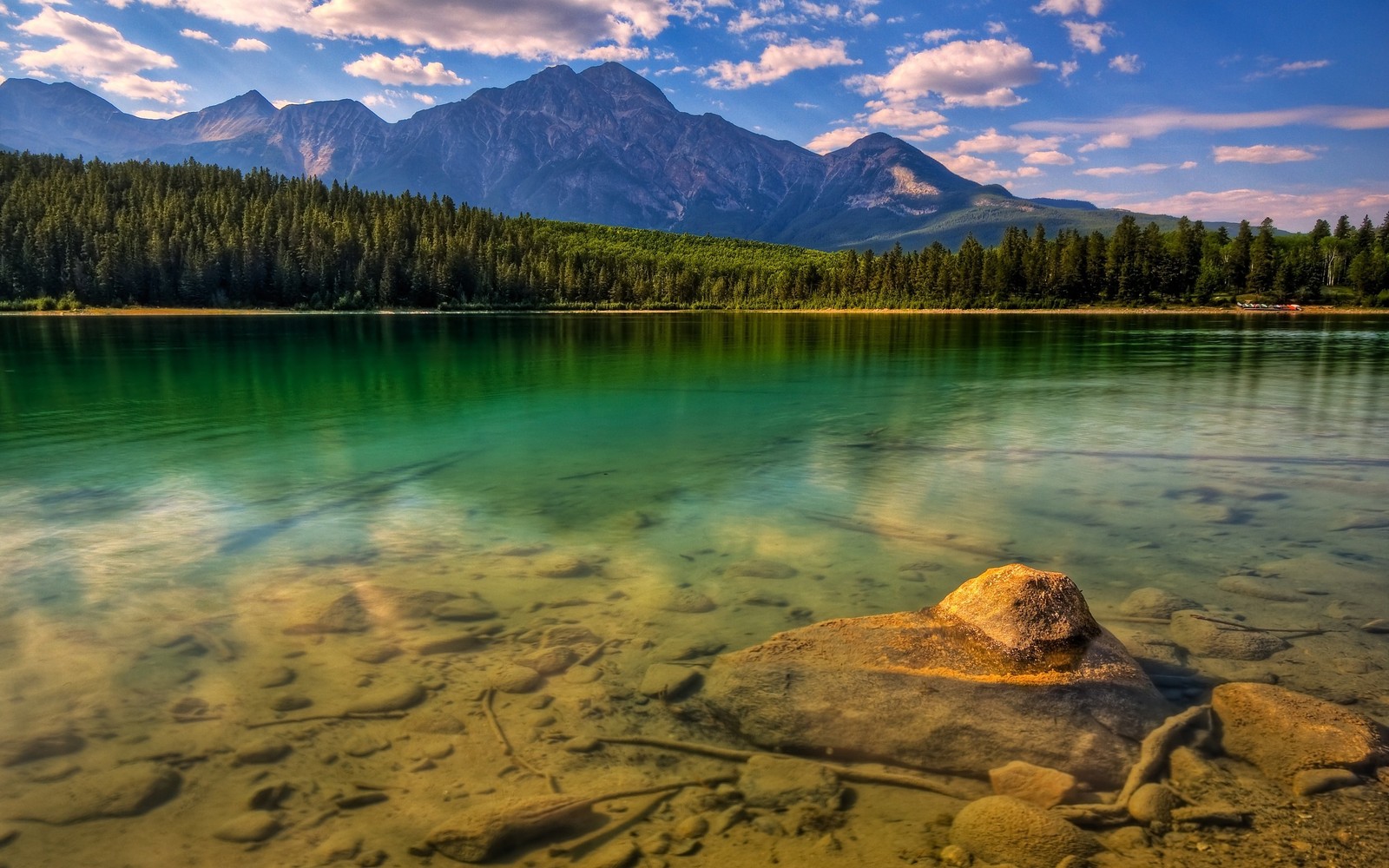 Uma grande rocha em cima de um lago ao lado de uma floresta (natureza, reflexo, wild, montanha, lago)