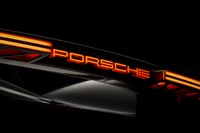 Porsche Mission X Vista trasera con logo iluminado en entorno oscuro