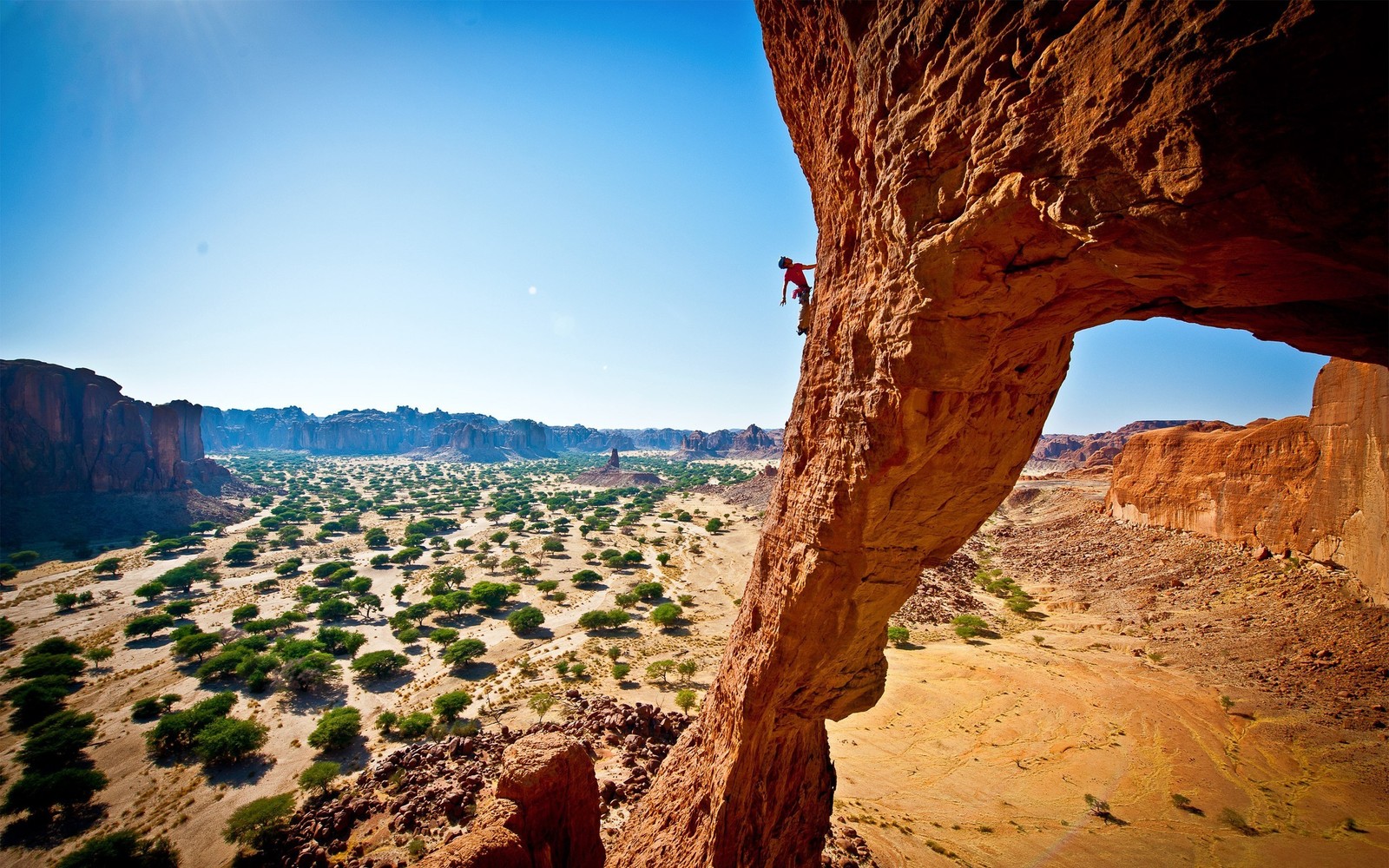 A man climbing up a cliff on a clear day (climbing, rock climbing, formation, rock, wilderness)