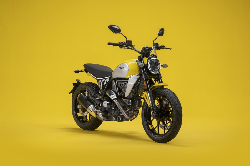 Крупный план мотоцикла, припаркованного на желтой поверхности (ducati scrambler icon, 2023, желтый фон, велосипеды, обои 4k)