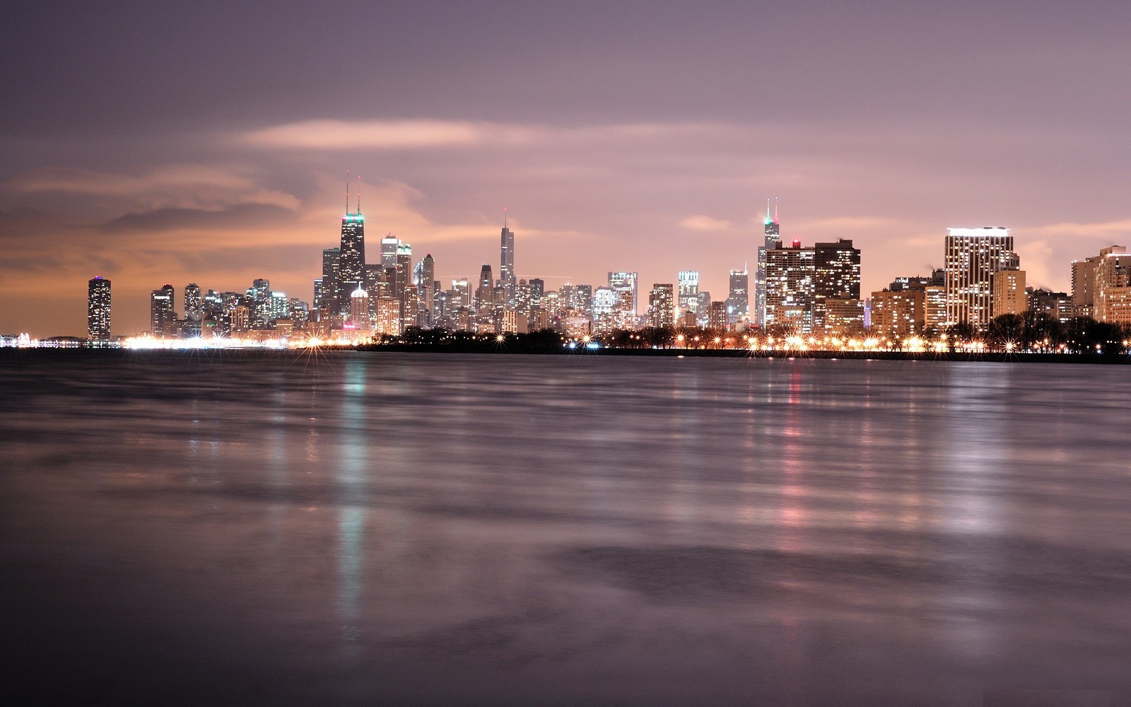 Vue d'un paysage urbain de nuit avec un lac devant. (horizon, paysage urbain, ville, zone urbaine, métropole)