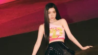 Irene de Red Velvet posant dans une tenue élégante avec un fond vibrant, célébrant son anniversaire.