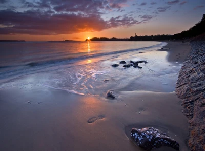 Atardecer sereno sobre una playa rocosa