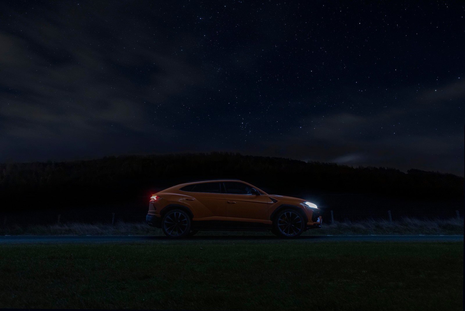 Une voiture est garée sur une route la nuit sous un ciel étoilé (lamborghini urus, nuit, ciel étoilé, 5k, noir foncé)