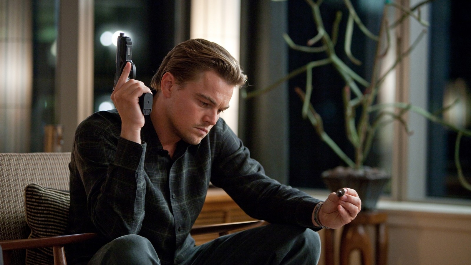 Homme arabe assis sur une chaise tenant un téléphone à l'oreille (leonardo dicaprio, film, acteur)