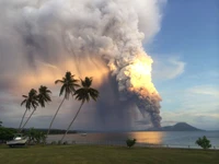 Erupção majestosa de estratovulcão cercada pelo mar e nuvens cúmulo