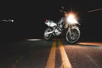 Moto illuminée sur une route sombre : une vitrine de l'éclairage automobile et de la performance