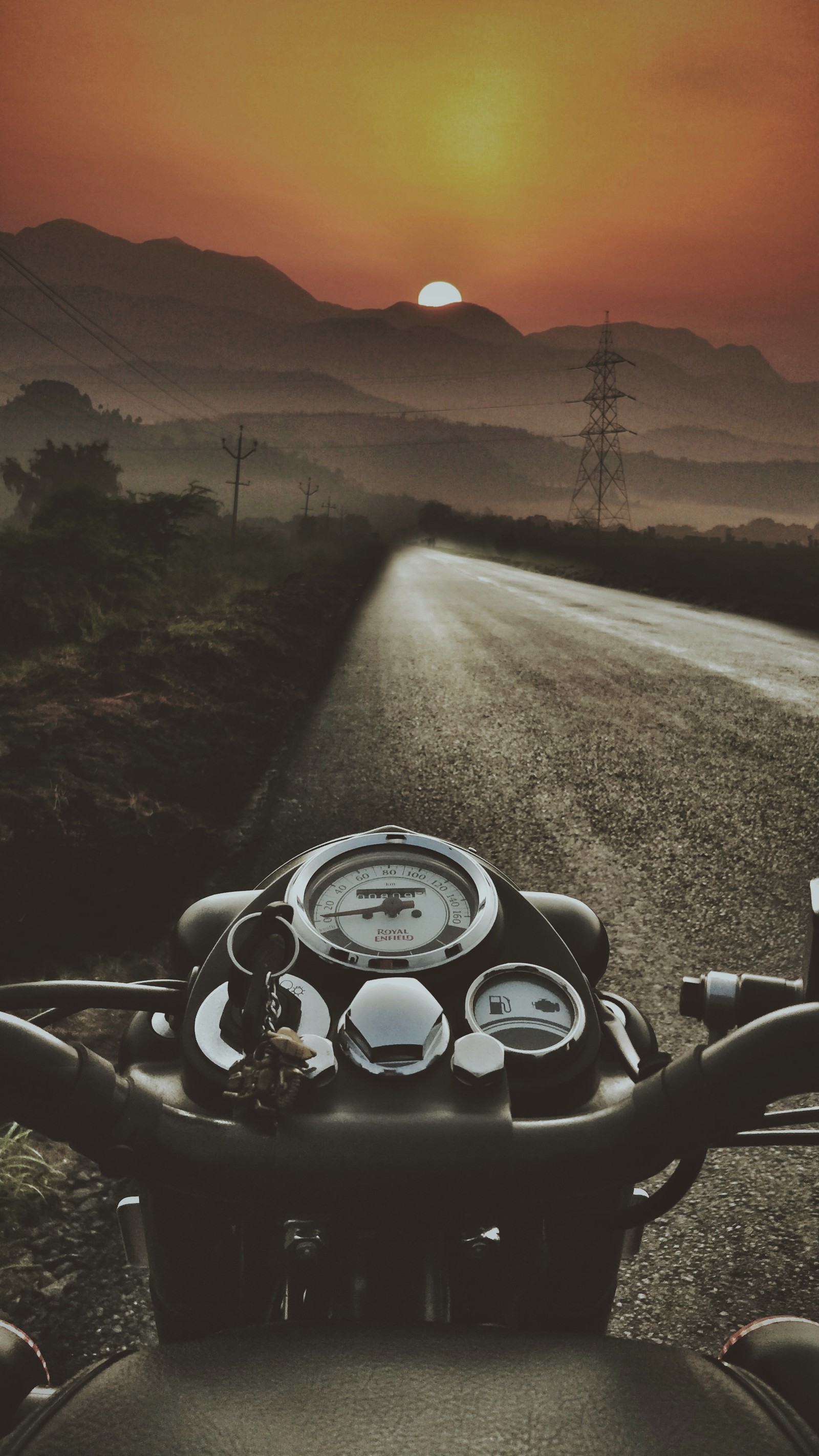 Arafed view of a motorcycle driving down a road at sunset (royal, enfield, classic, stealth, black)