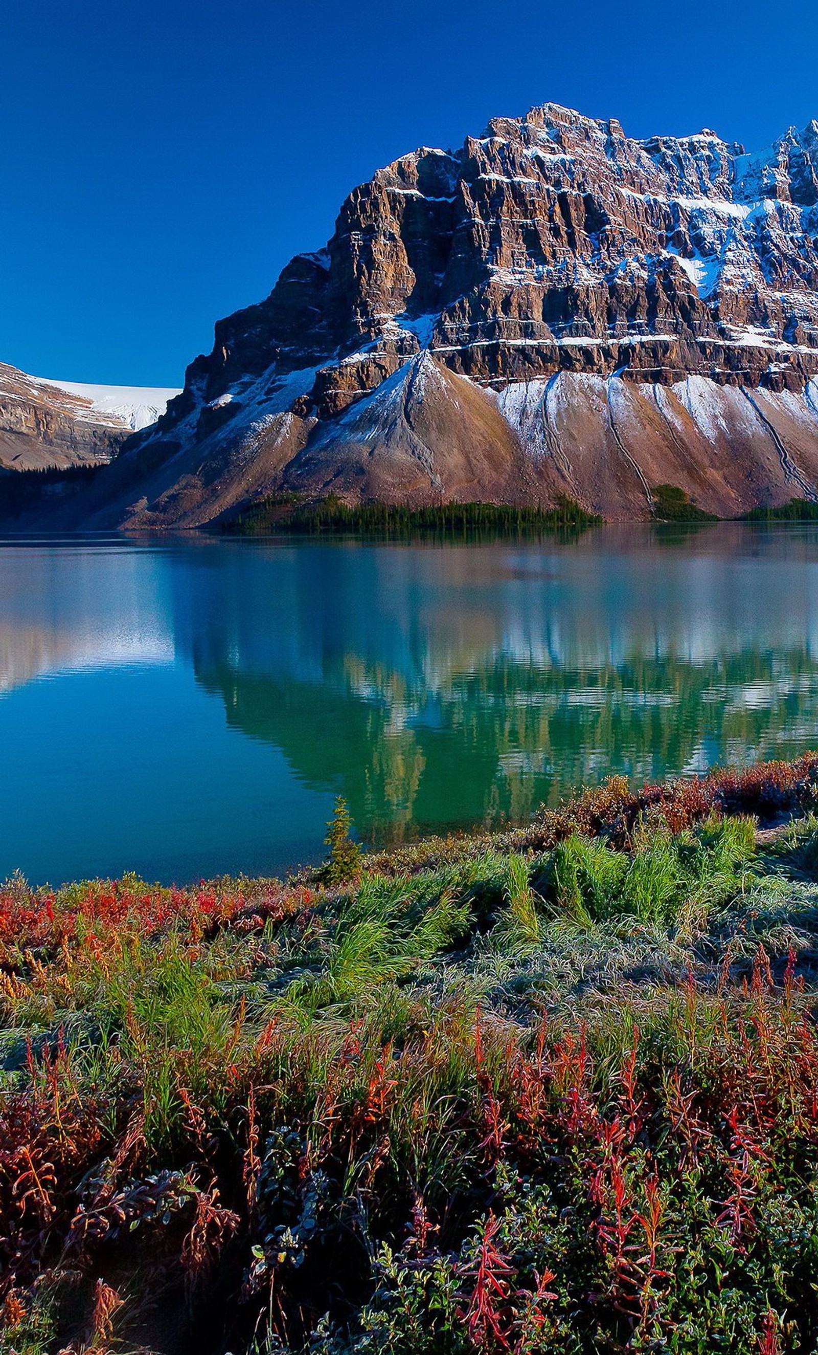 Montañas y un lago con nieve en la cima y un cielo azul (lago, pradera, montaña, naturaleza, agua)