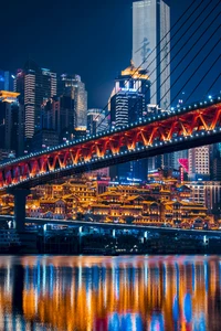 Vibrant Cityscape at Night: Skyscrapers and Bridge Reflections in a Metropolis