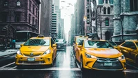 Taxis amarillos navegando por una calle lluviosa de Manhattan