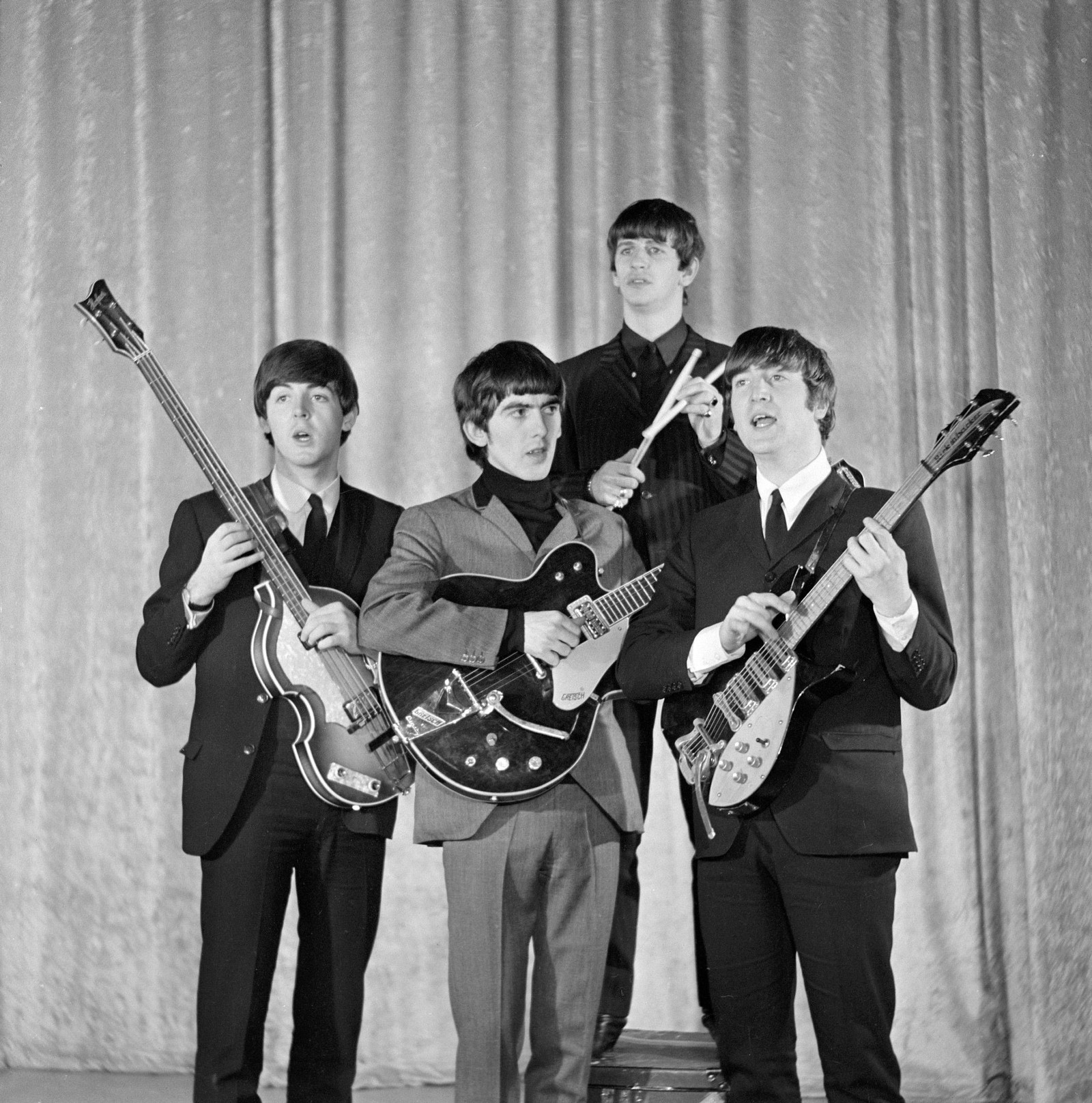 Arafed black and white photo of a group of men with guitars (ringo starr, george harrison, the beatles, string instrument, musical instrument)